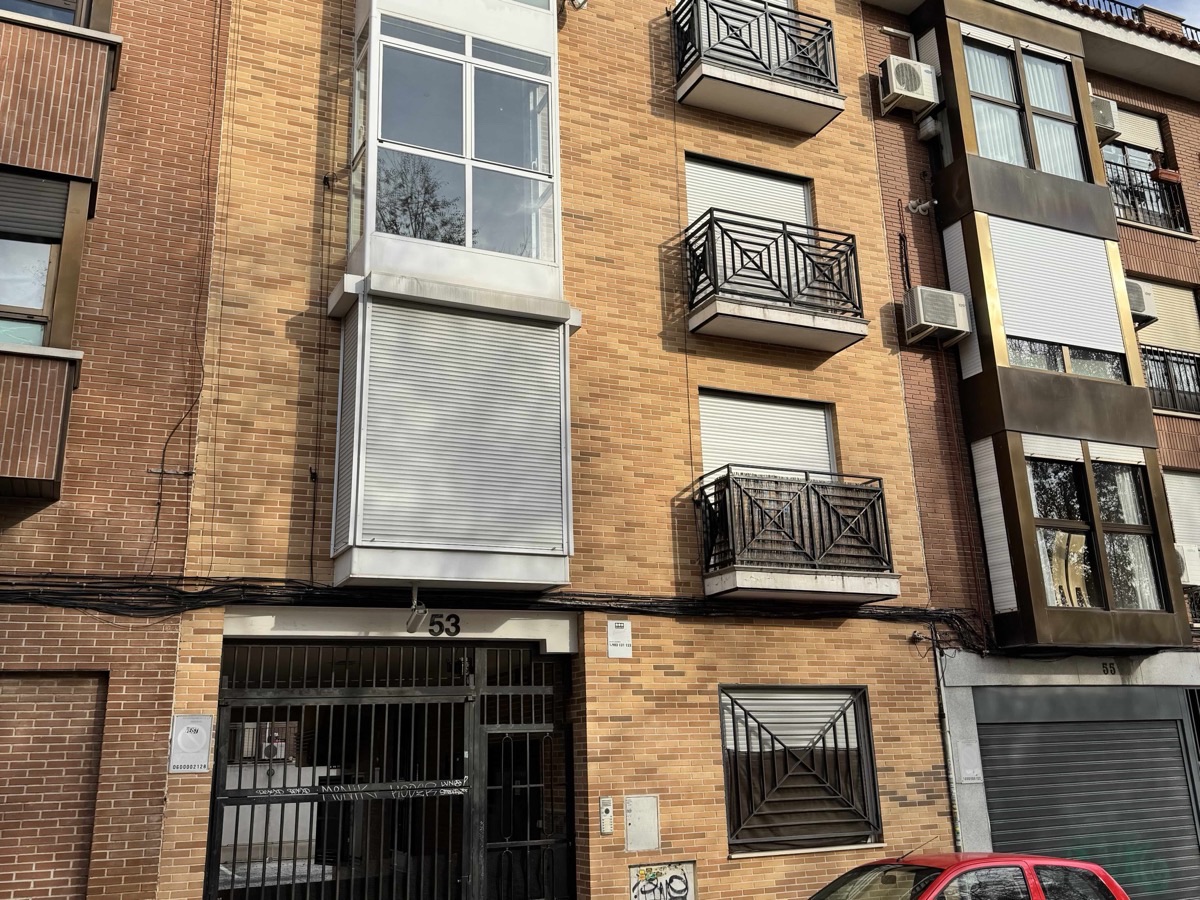Fachada de ladrillo de un edificio de viviendas con balcones y portal